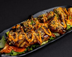 Pork Belly garnished with sauce and sesame seeds