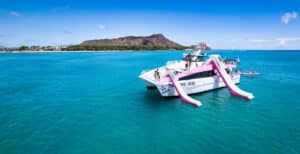 Pink Sails Waikiki Boat in the middle of the ocean in front of diamond head